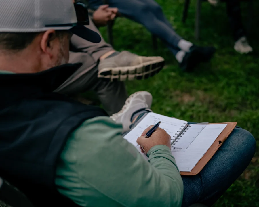 An attendee taking notes during an outdoor session