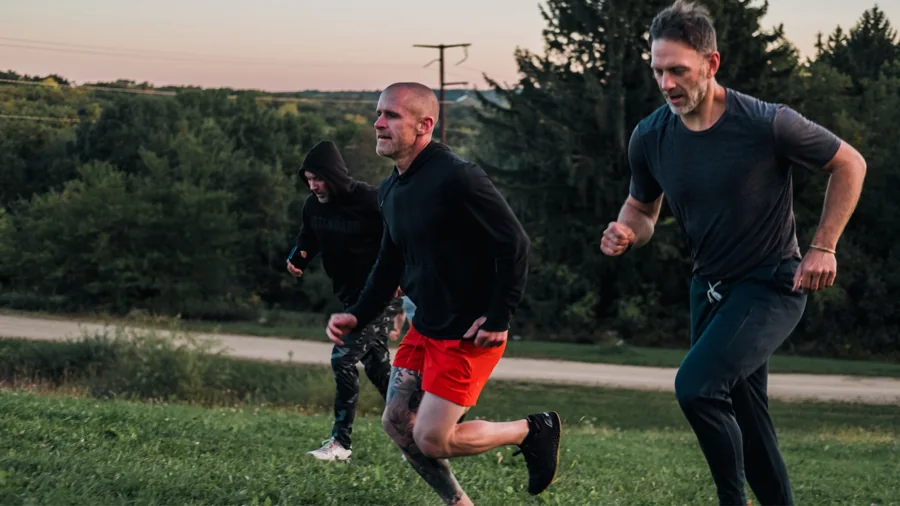 Two attendees running outdoors at sunrise